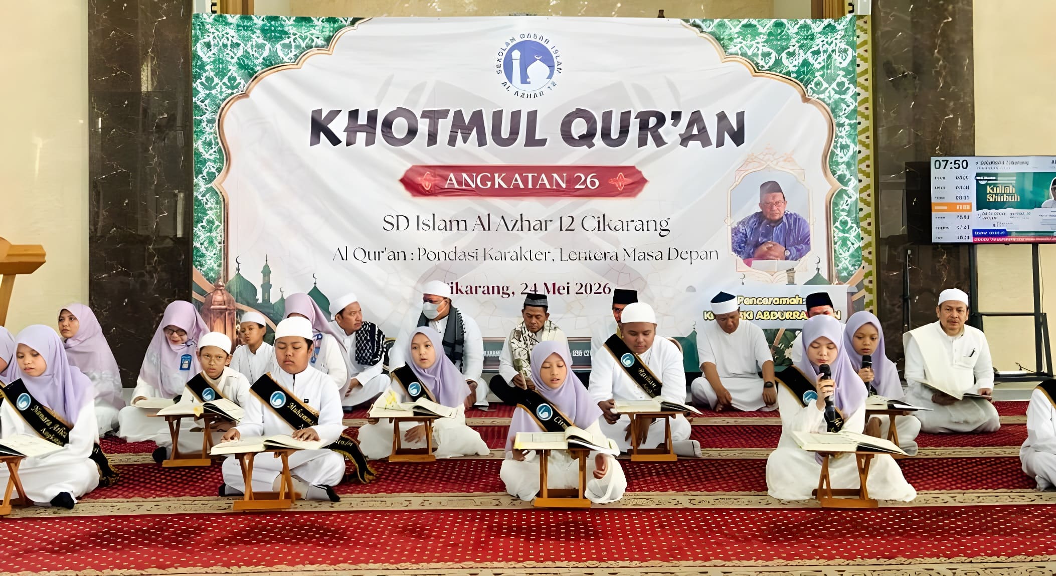 Prosesi tasyakur Khatmul Quran Angkatan 26 di mana murid-murid SD Islam Al Azhar 12 Cikarang membaca Al-Quran bersama di atas panggung menggunakan rehal.