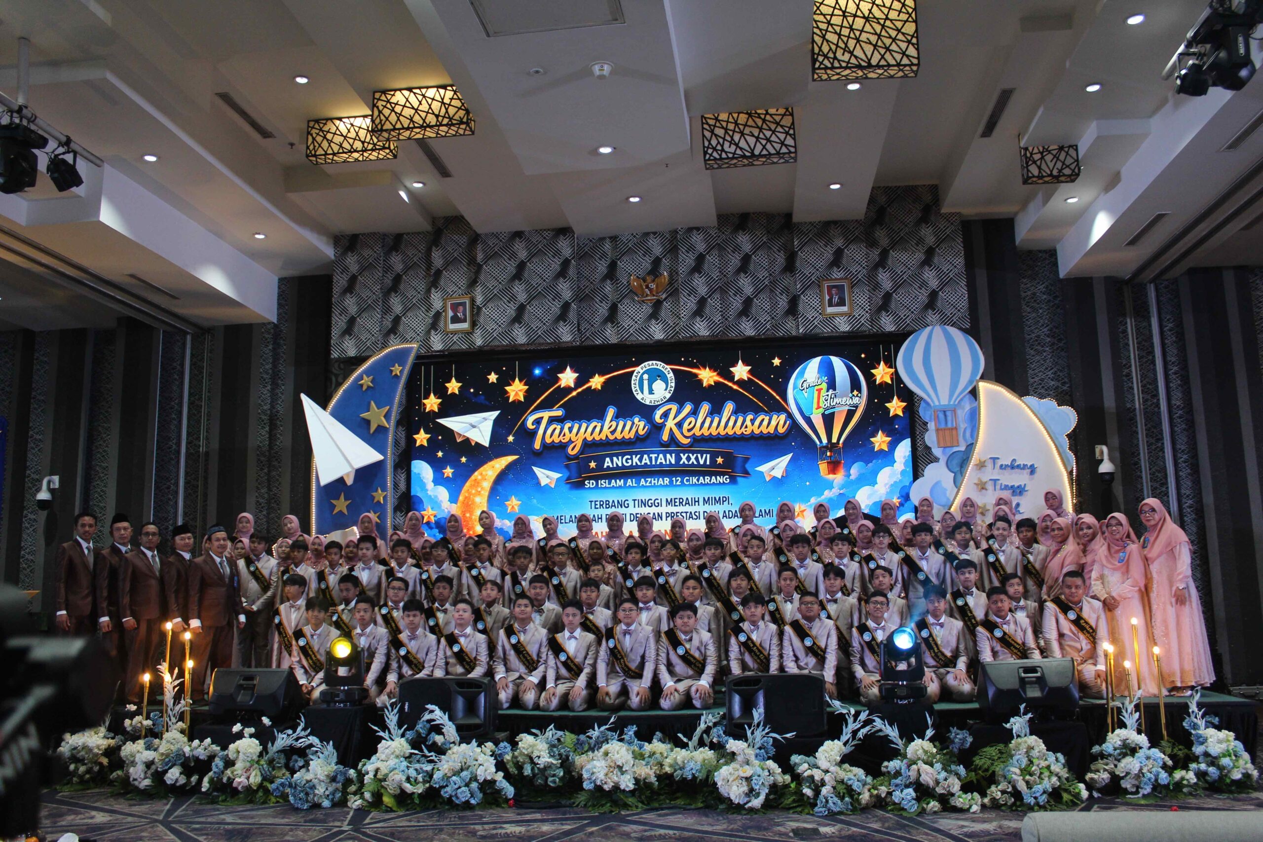 Foto bersama seluruh murid lulusan Angkatan 26 bersama jajaran guru dan karyawan SD Islam Al Azhar 12 Cikarang di panggung megah.